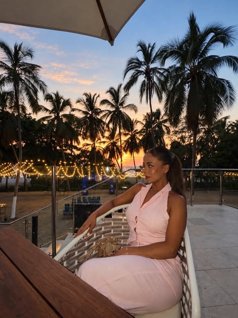 Madel Cuza al atardecer junto a palmeras